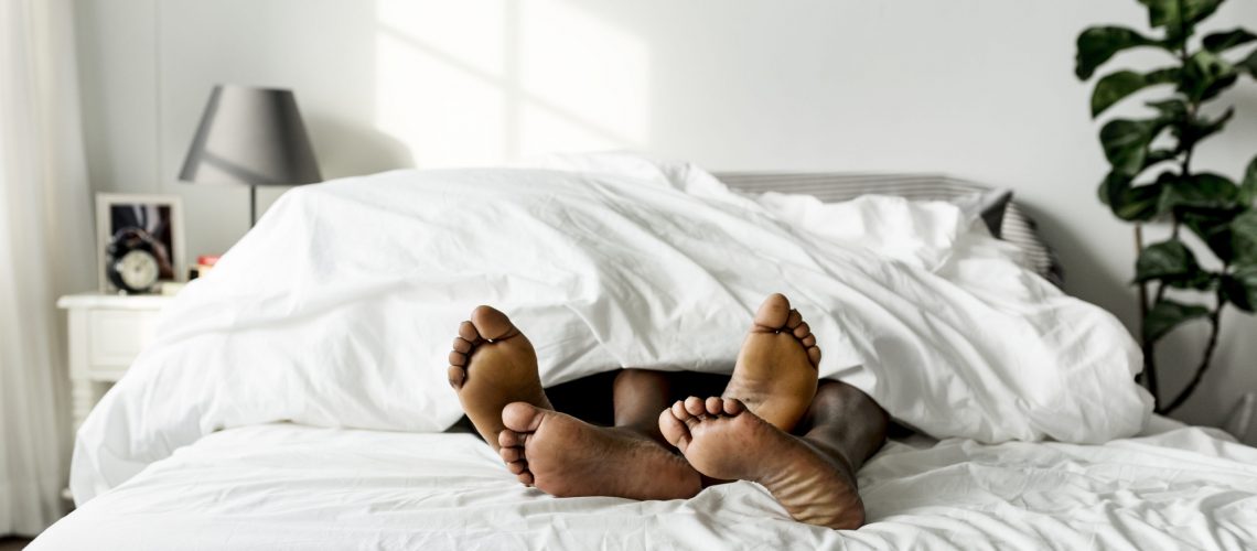 Black couple lying on bed together sex concept